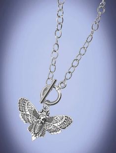 Introducing our Silver Goth Moth Charm Necklace, a captivating piece that beautifully combines elegance and mystique. Crafted with meticulous attention to detail, this enchanting necklace showcases the delicate charm of a moth in stunning silver. The pendant of the necklace portrays a gracefully poised moth, its wings expertly fashioned with intricate patterns. Each delicate curve and vein is expertly rendered, capturing the ethereal beauty of this nocturnal creature. The silver craftsmanship br Gothic Sterling Silver Necklace With Lobster Clasp, Festival Butterfly Charm Necklaces, Festival Butterfly Charm Necklace, Goth Moth, Moth Necklace, Goth Necklace, Goth Jewelry, Witchy Jewelry, Ethereal Beauty