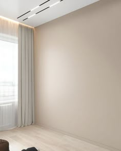 an empty room with white walls and wooden flooring is pictured in this image, there are two suitcases on the floor next to the window