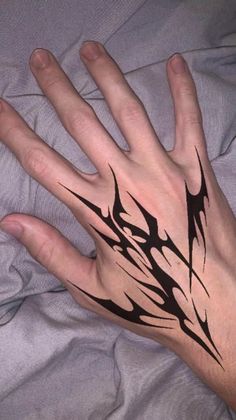 a person's hand with black ink on it and an abstract design in the middle