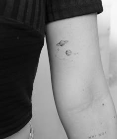 a woman's arm with two planets on it and the words why not written in black ink