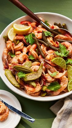 a white bowl filled with shrimp and veggies on top of a green table