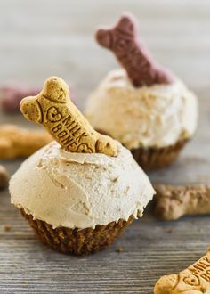 two cupcakes with white frosting and chocolate decorations