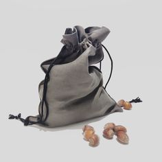 a drawsack bag with three small nuts in front of it on a white surface