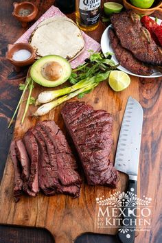 steak, avocado, and other ingredients on a cutting board with a knife