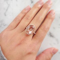 a woman's hand with a pink diamond ring on top of her left hand