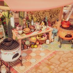 an outdoor cooking area with pots, pans and other items on the table in front of it