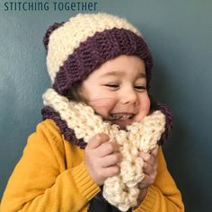 a young child wearing a knitted hat and scarf with the words stitching together on it