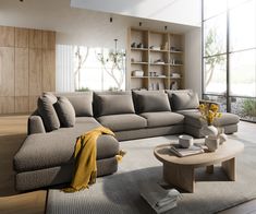 a living room with a large sectional couch and coffee table in front of a window