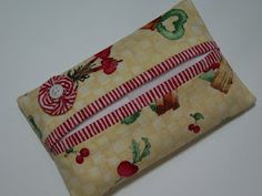 a piece of fabric with red and green designs on it, sitting on a white surface