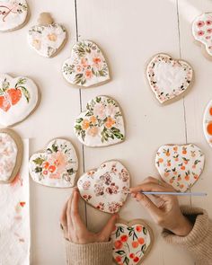 a woman is making heart shaped cookies with flowers on the top and hearts in the middle