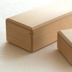 two pieces of wood sitting next to each other on a white tablecloth covered surface