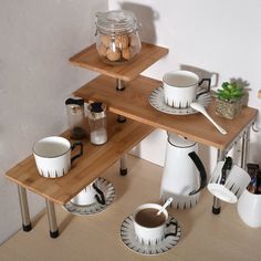 two wooden shelves with coffee cups and saucers on them, one shelf is made out of wood