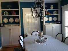 the dining room table is set with white plates and silverware, which are on display