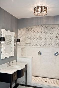 a bathroom with a sink, mirror and shower stall in the middle of the room