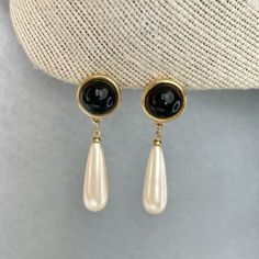 "Vintage Monet Dangle Drop Earrings, Gold Tone Cream White Long Bead and Black Cabochon Earrings, Signed Estate Jewelry, Gift for Her. Era: After 1955.  Designer Signed: Monet.  Measurements: - Length: 1 7/8\" inches.  - Width: 1/2\" inches.  Details: - Embellishments: Gold Tone Plating,  Cream-White Long drop shaped beads, Black Cabochons, Dangle Earrings.  - Closure: Push Backs.  Here are more Vintage Jewelry items for your viewing pleasure: https://etsy.me/2SGhTFo Our shop team members do our best to research and identify items correctly and do our best to point out and identify any issues with pieces. Please examine the pictures closely as these are part of the description. Please bear in mind that most of the pieces we offer are vintage and antique and will sometime have some minor we Elegant Black Teardrop Pearl Earrings, Classic Black Pearl Drop Earrings, Black Dangle Pearl Earrings For Formal Occasions, Black Teardrop Earrings With Pearl Drop, Black Teardrop Pearl Drop Earrings, Black Pearl Drop Teardrop Earrings, Cabochon Earrings, Drop Earrings Gold, Vintage Monet