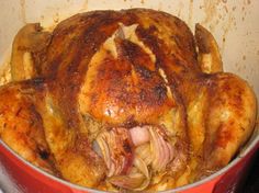 a cooked turkey in a red pot on the stove