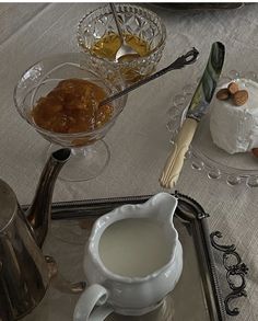 there is a silver tray with cups and spoons on it, along with other dishes