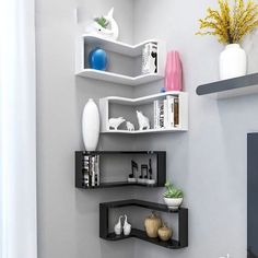 three shelves with vases, books and other items on them in the corner of a room