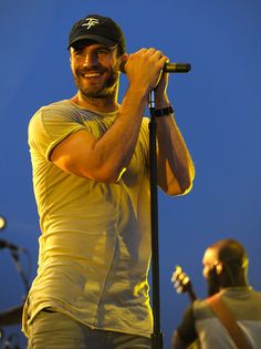 a man holding a microphone on top of a stage