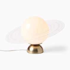 an egg lamp is sitting on top of a metal base and has a white light bulb