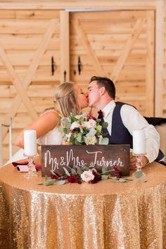 a bride and groom kissing in front of their sign that says mr & mrs summer