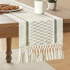 a table runner with tassels on it and a plate of food next to it