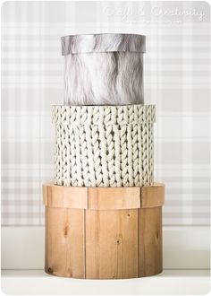 a white and gray basket sitting on top of a wooden stand