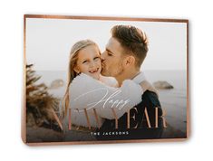 a wooden plaque with the words happy new year and a photo of a couple kissing