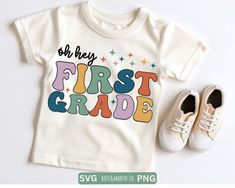 a t - shirt with the words first grade on it next to shoes and a pair of sneakers