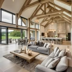 a large open living room with high ceilings and wooden beams on the ceiling is lit by candles