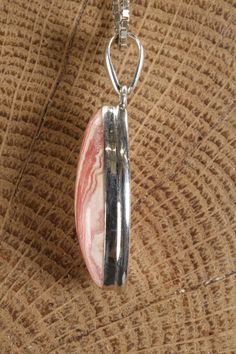 Rhodochrosite Marquise Pendant Approx. Dimensions: 30x15x8 mm This pendant is made with .925 Sterling Silver. Chain is not included. Rhodochrosite is a manganese carbonate mineral recognized for its distinctive pink to rose-red color. It is commonly found in various locations worldwide, including Argentina, Peru, South Africa, and the United States. Historically, rhodochrosite has been known since ancient times and has been utilized as an ornamental stone in jewelry and carvings. Its name is der Unique Pink Jewelry With Large Pendant, Silver Rhodonite Jewelry With Natural Stones, Rhodonite Gemstone Jewelry For Gift, Silver Jewelry With Natural Stones And Rhodonite, Pink Agate Pendant Jewelry, Pink Opal Pendant Jewelry, Marquise Pendant, 925 Sterling Silver Chain, Ancient Times