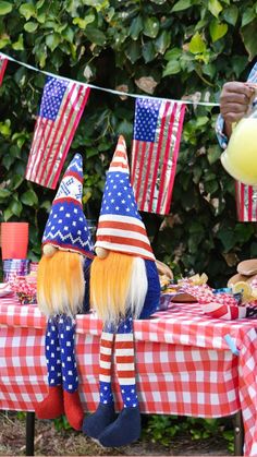 two gnomes sitting at a table with american flags on it