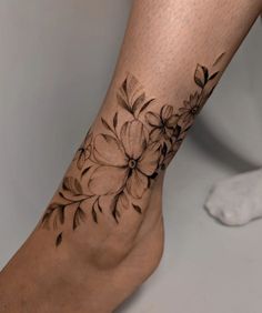 a close up of a person's foot with flowers tattooed on the bottom of it