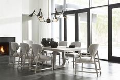 a dining room table with white chairs and a fire place in the corner next to it