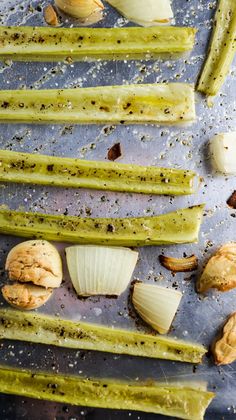 several different types of vegetables on a baking sheet with garlic and other things in the background