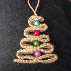 a crocheted christmas tree ornament hanging from a man's lap