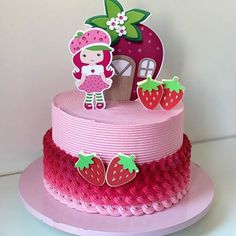 there is a pink cake decorated with strawberries and a girl standing on the top