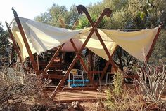 an outdoor structure made out of wood and canvas