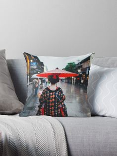 a woman with an umbrella walking down the street in the rain throw pillow on a couch