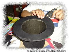 a person holding a black hat in their hands