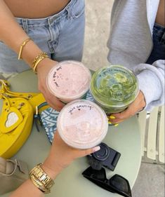 three people are holding cups with drinks in them