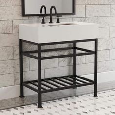 a white sink sitting under a bathroom mirror next to a tiled wall with black accents