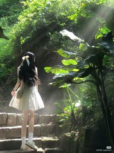 a woman standing on some steps in the woods with sunbeams coming through her hair