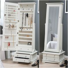 a white jewelry cabinet sitting next to a mirror