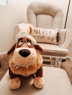 a stuffed dog sitting on top of a table in front of a chair and pillow