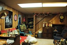 a living room filled with lots of furniture next to a wooden wall covered in christmas lights