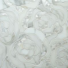 white marble tile with flowers and leaves on the bottom, as well as an intricate design