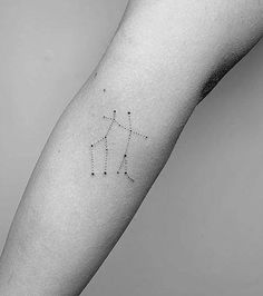 a person's arm with a small star tattoo on the left side of their arm