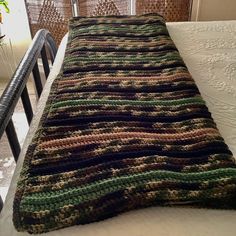 a crocheted blanket sitting on top of a bed