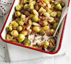 a red casserole dish filled with brussel sprouts and bacon